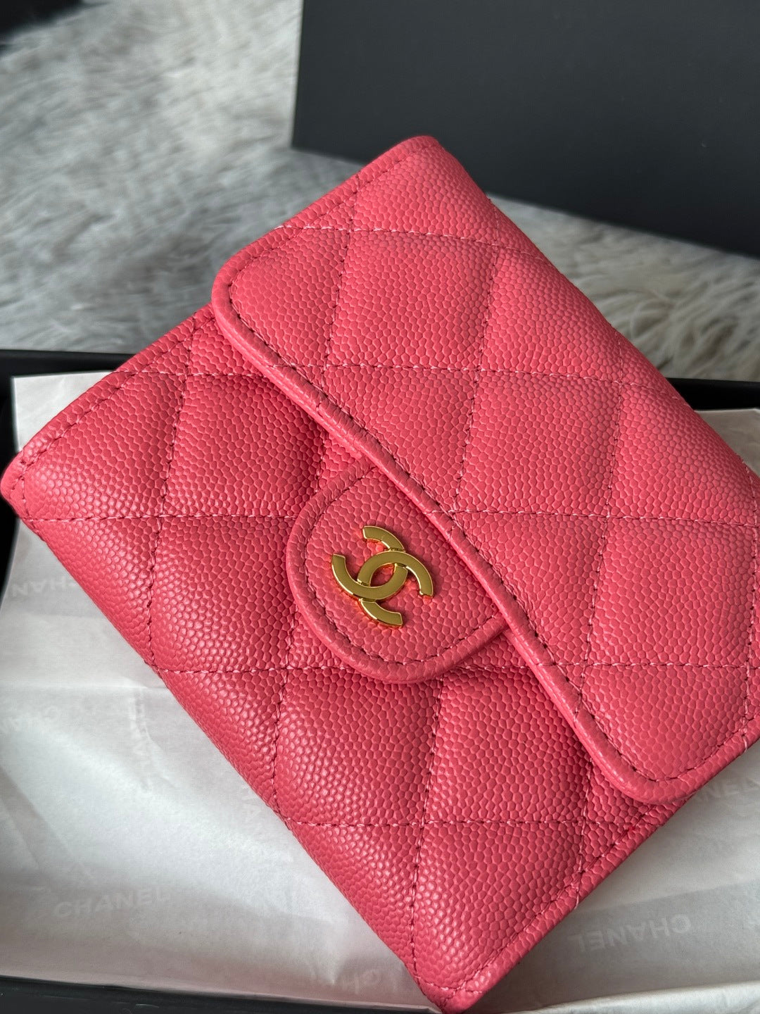 Pink quilted leather flap bag with gold CC emblem, close-up detail