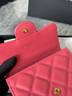 Pink quilted flap bag with gold CC button clasp, close-up
