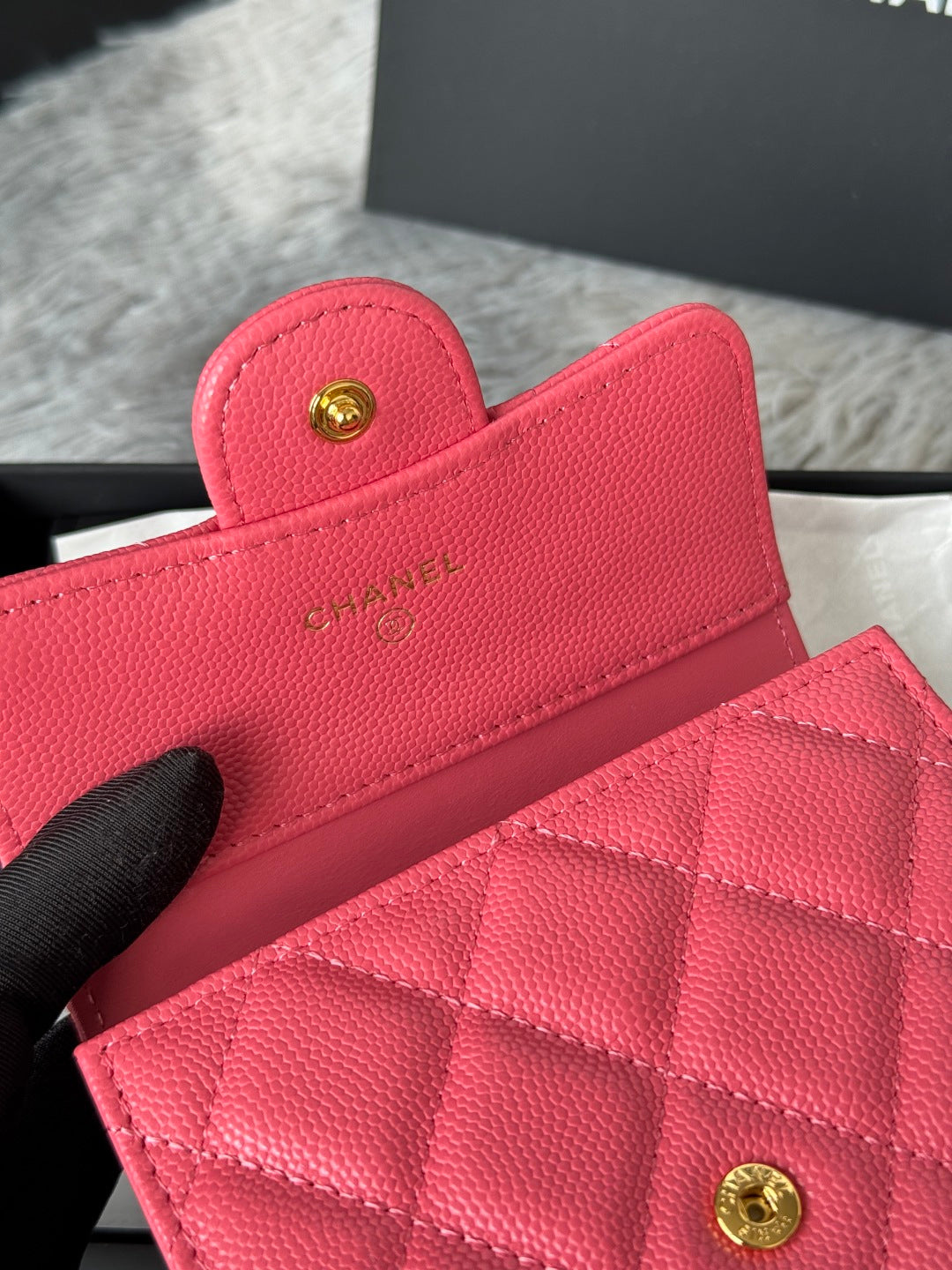 Pink quilted flap bag with gold CC button clasp, close-up