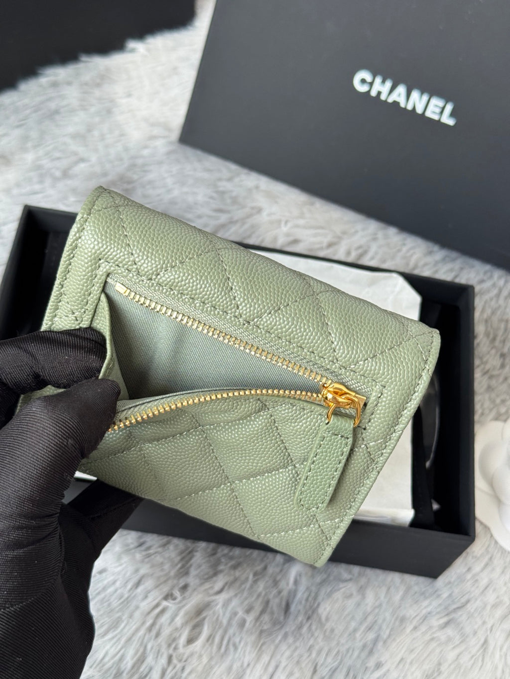 Light green quilted small bag with gold zipper and front detail