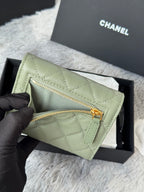 Light green quilted small bag with gold zipper and front detail