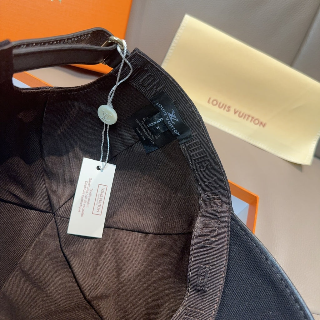 Black Louis Vuitton cap with adjustable strap and hanging tag.