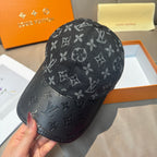 Louis Vuitton monogram cap with dark leather-look brim, handheld side view