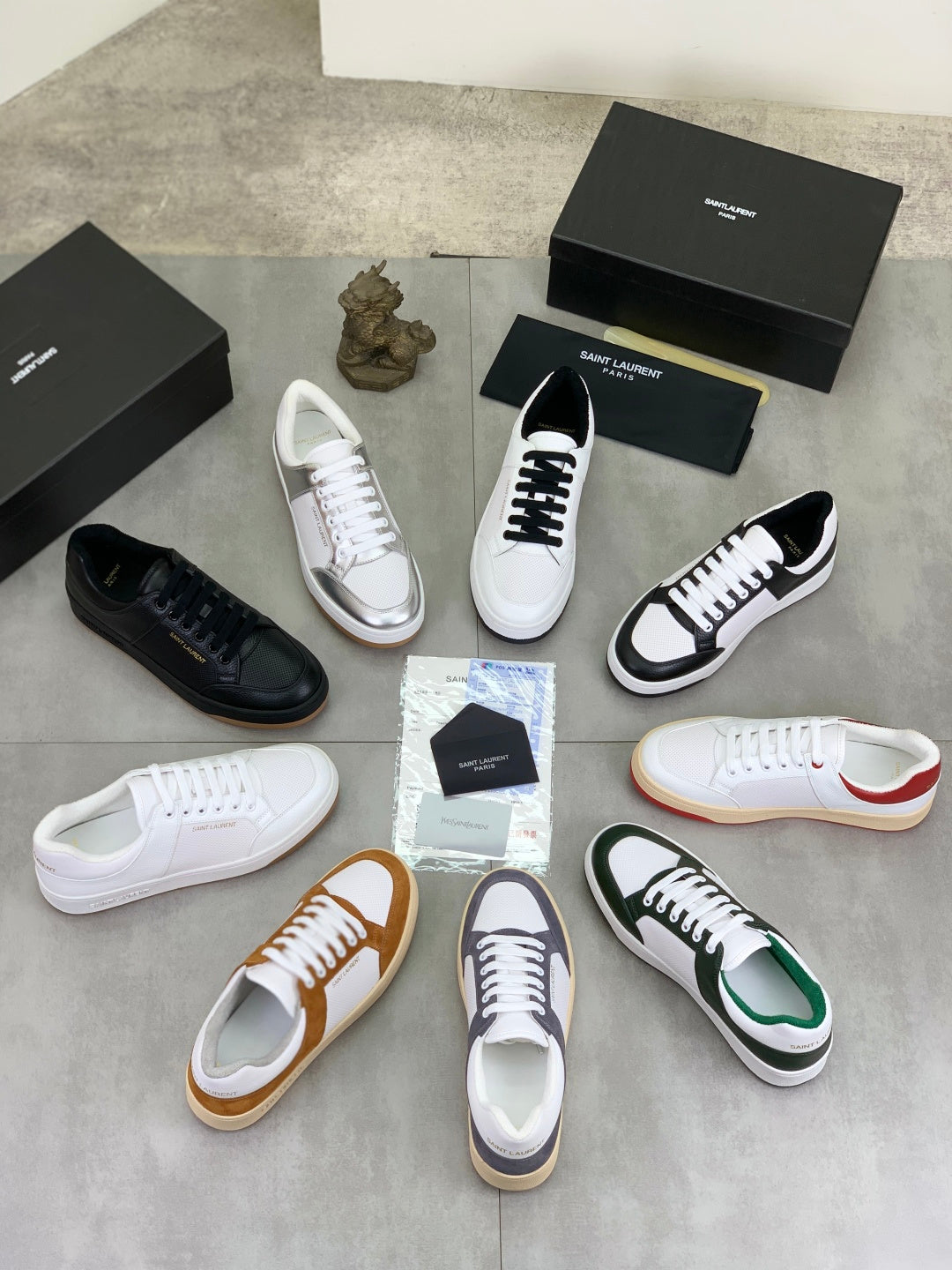Assorted low-top sneakers in white, black, cream, and tan with laces and rubber soles.