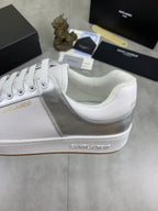 White and silver low-top sneakers with white laces and stitched panel detail.