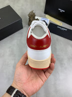 Back view of white sneaker with red heel collar and “Saint Laurent” logo.