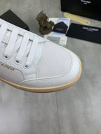 White sneaker toe and side panel detail with laces and gum rubber trim.