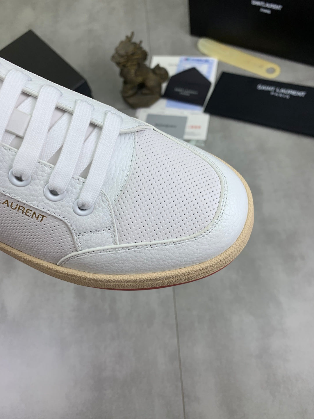White sneaker toe and side panel detail with laces and gum rubber trim.