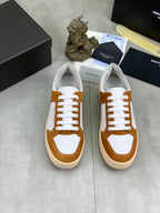 Pair of brown and white lace-up sneakers with off-white soles, SAINT LAURENT on tongue.