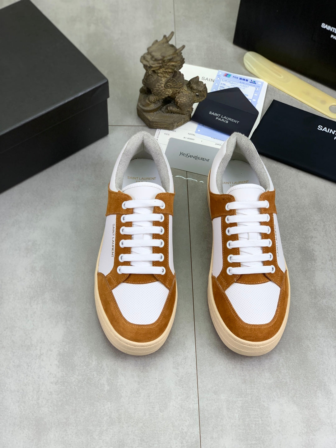 Pair of brown and white lace-up sneakers with off-white soles, SAINT LAURENT on tongue.