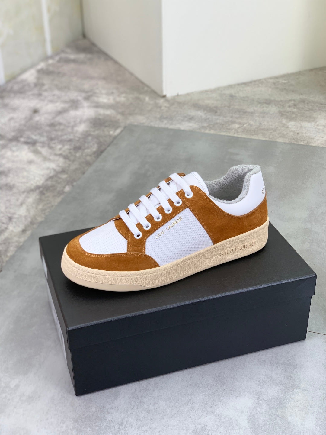Brown suede and white low-top sneakers with white laces and off-white rubber sole.