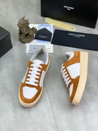 Brown suede and white low-top sneakers with lace-up closure and SAINT LAURENT branding.