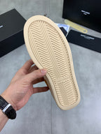 Sneaker outsole with herringbone tread and beige rubber sole, SAINT LAURENT text.