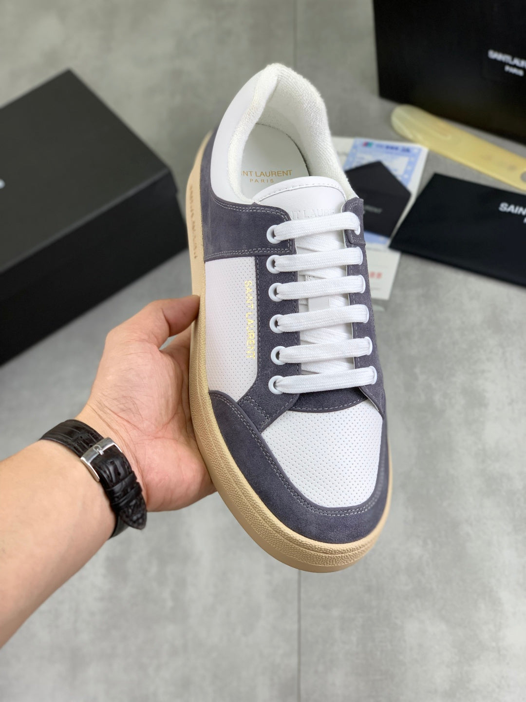 Low-top sneakers: white leather, navy panels, white laces, tan/gum sole.
