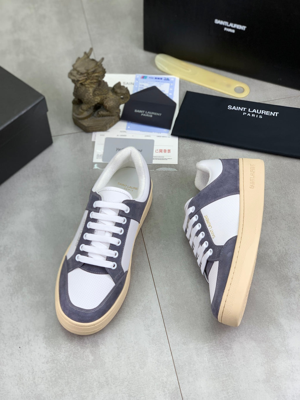 Low-top sneakers with navy and white colorblock, white laces, tan gum sole.