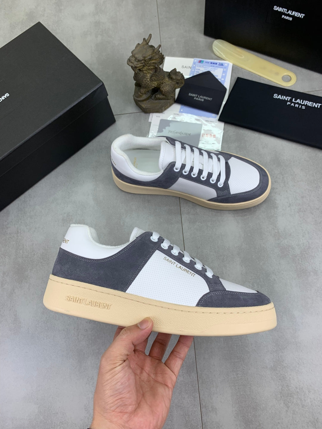 Low-top sneakers pair, white leather and navy suede, white laces, gum sole.