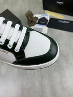 Luxury shoes close-up: white perforated toe with dark green leather side and white laces