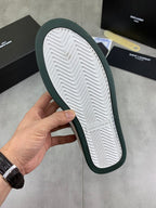 Luxury shoes outsole view with dark green edge and white chevron tread