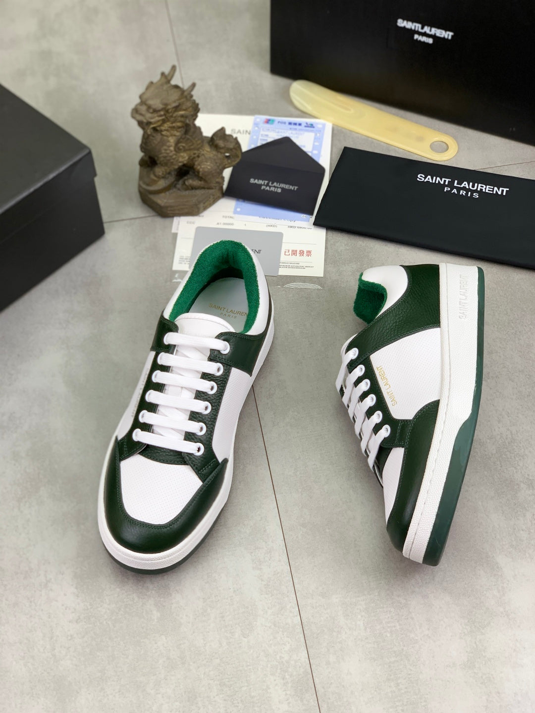 Luxury shoes in white and dark green with white laces and visible side branding