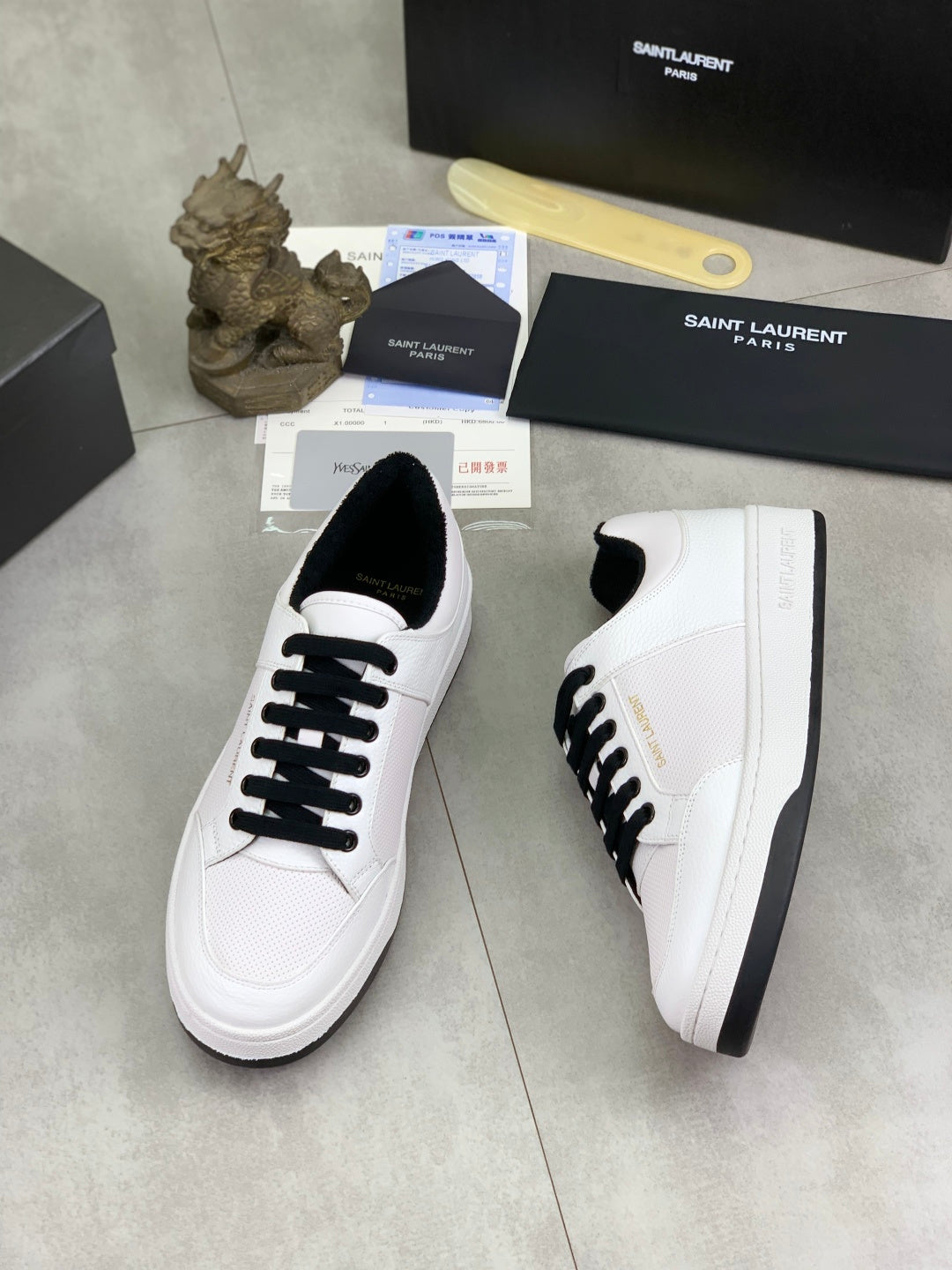 White low-top sneakers, angled view, black lace-up detail and sole