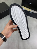White sneaker outsole view with black edge and herringbone tread