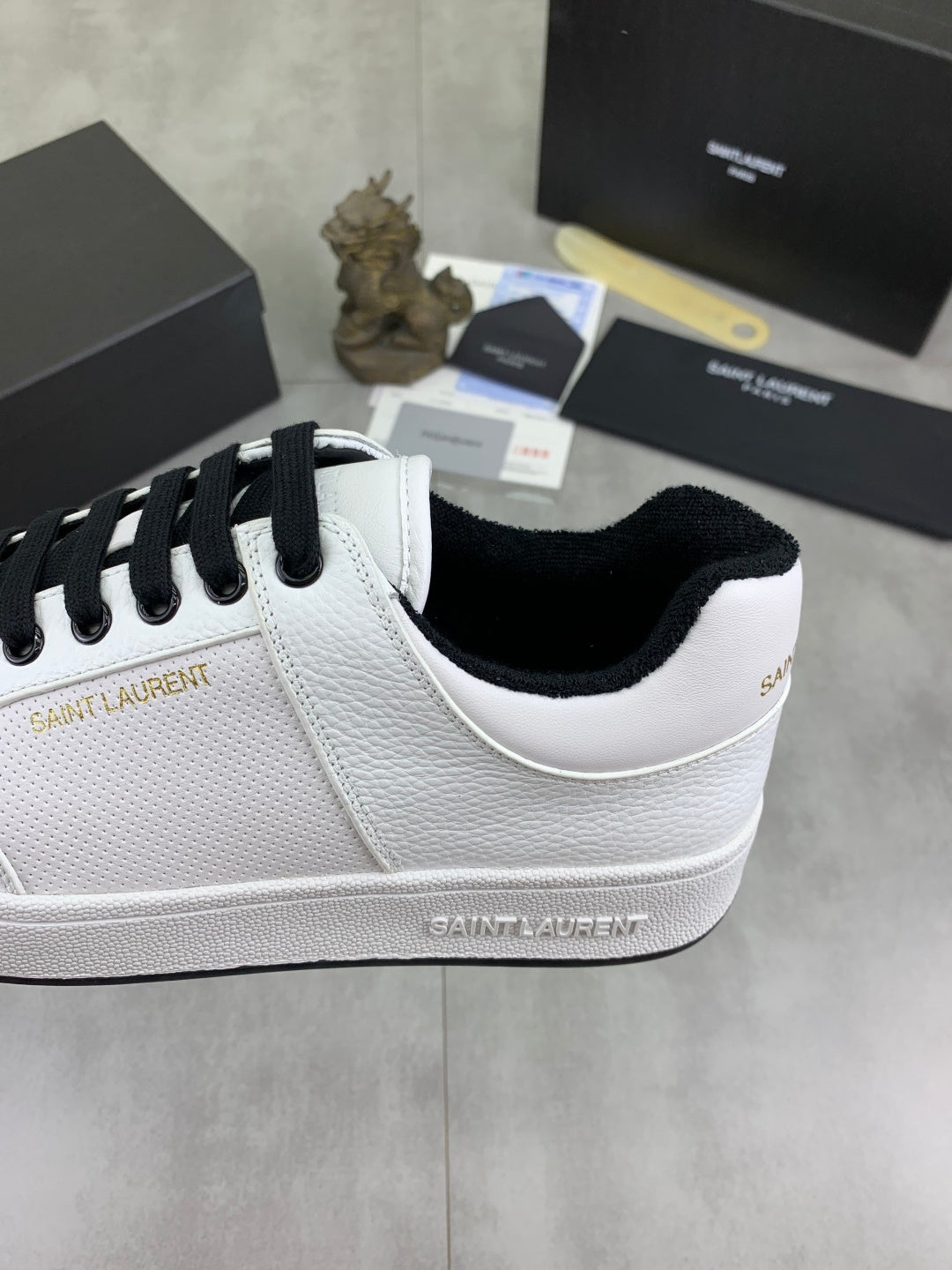 White low-top sneakers with black laces and black-trim collar