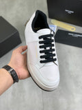 White low-top sneakers with black lace-up front and cushioned sole edge