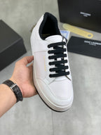 White low-top sneakers with black lace-up front and cushioned sole edge