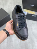 Black lace-up sneakers with textured upper and dark rubber sole