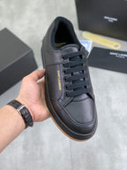 Black lace-up sneakers with textured upper and dark rubber sole