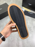 Black sneaker outsole with zigzag tread and tan rubber edge
