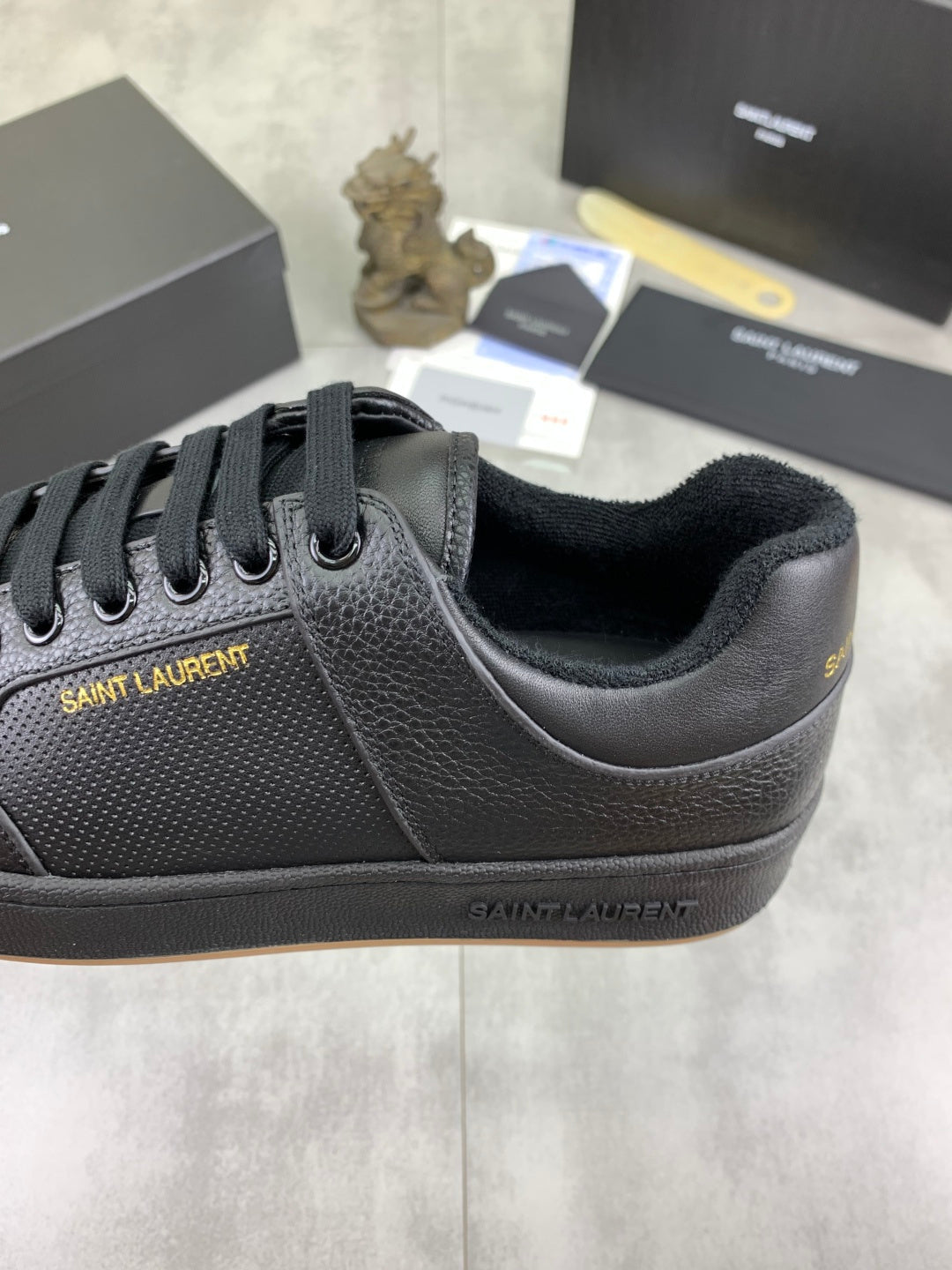 Black lace-up sneakers with textured leather upper and padded collar