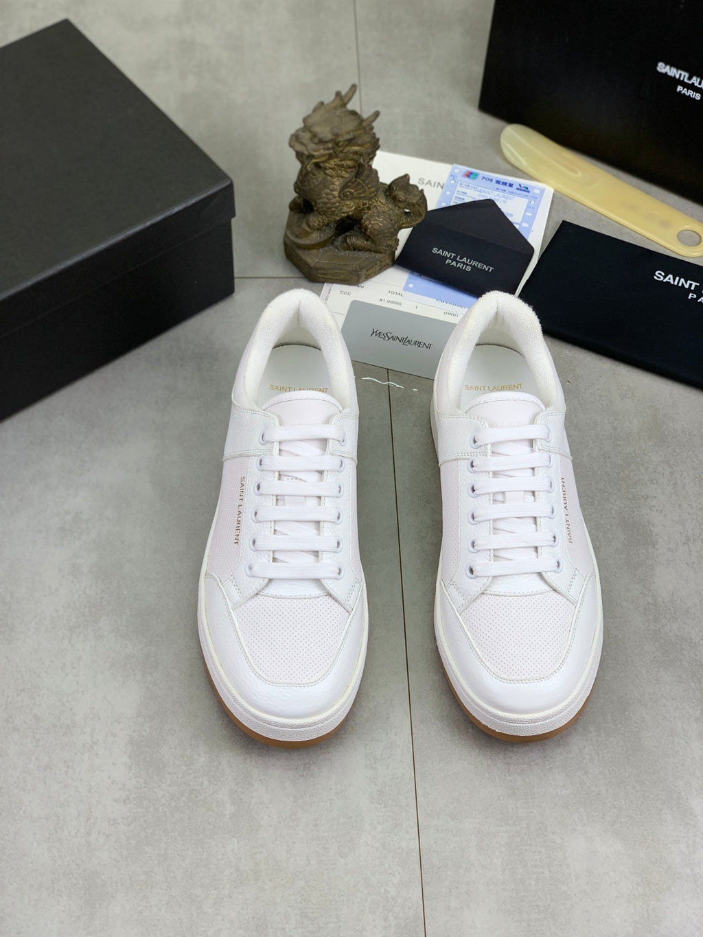Pair of white low-top lace-up sneakers with flat rubber sole