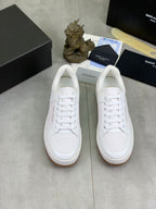 Pair of white low-top lace-up sneakers with flat rubber sole