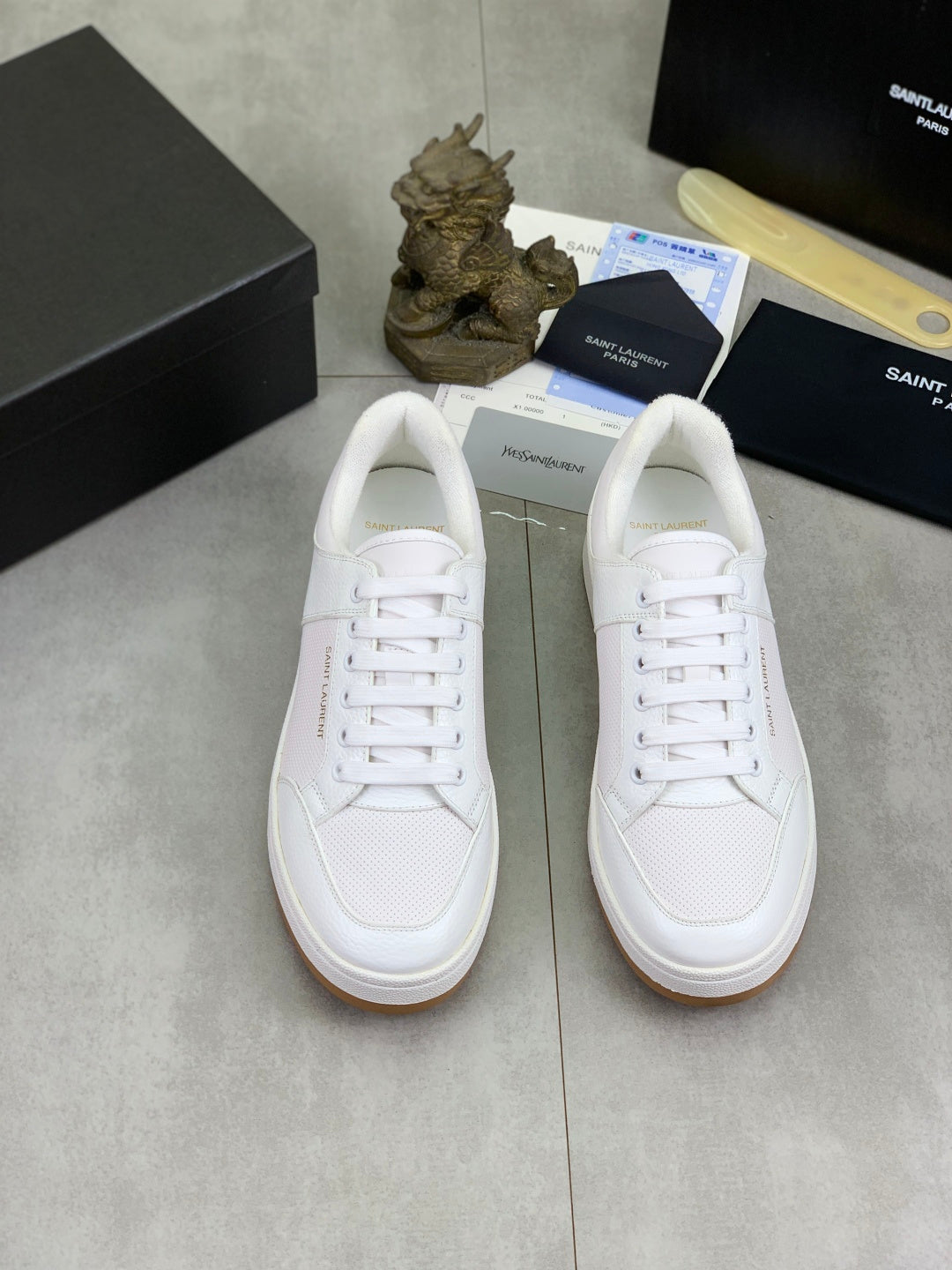 Pair of white low-top lace-up sneakers with flat rubber sole