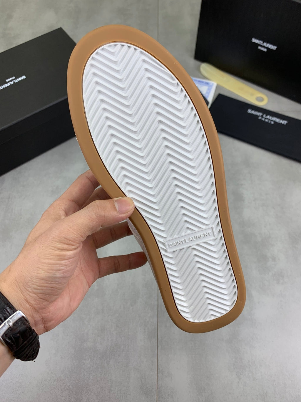 White rubber outsole with zigzag tread on a gum-colored sneaker sole