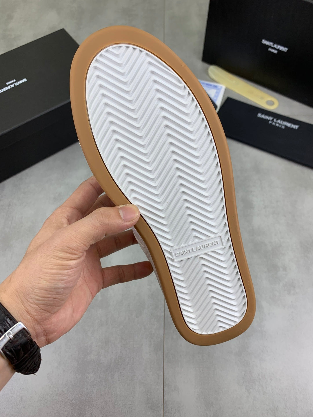 White rubber outsole with zigzag tread on a gum-colored sneaker sole