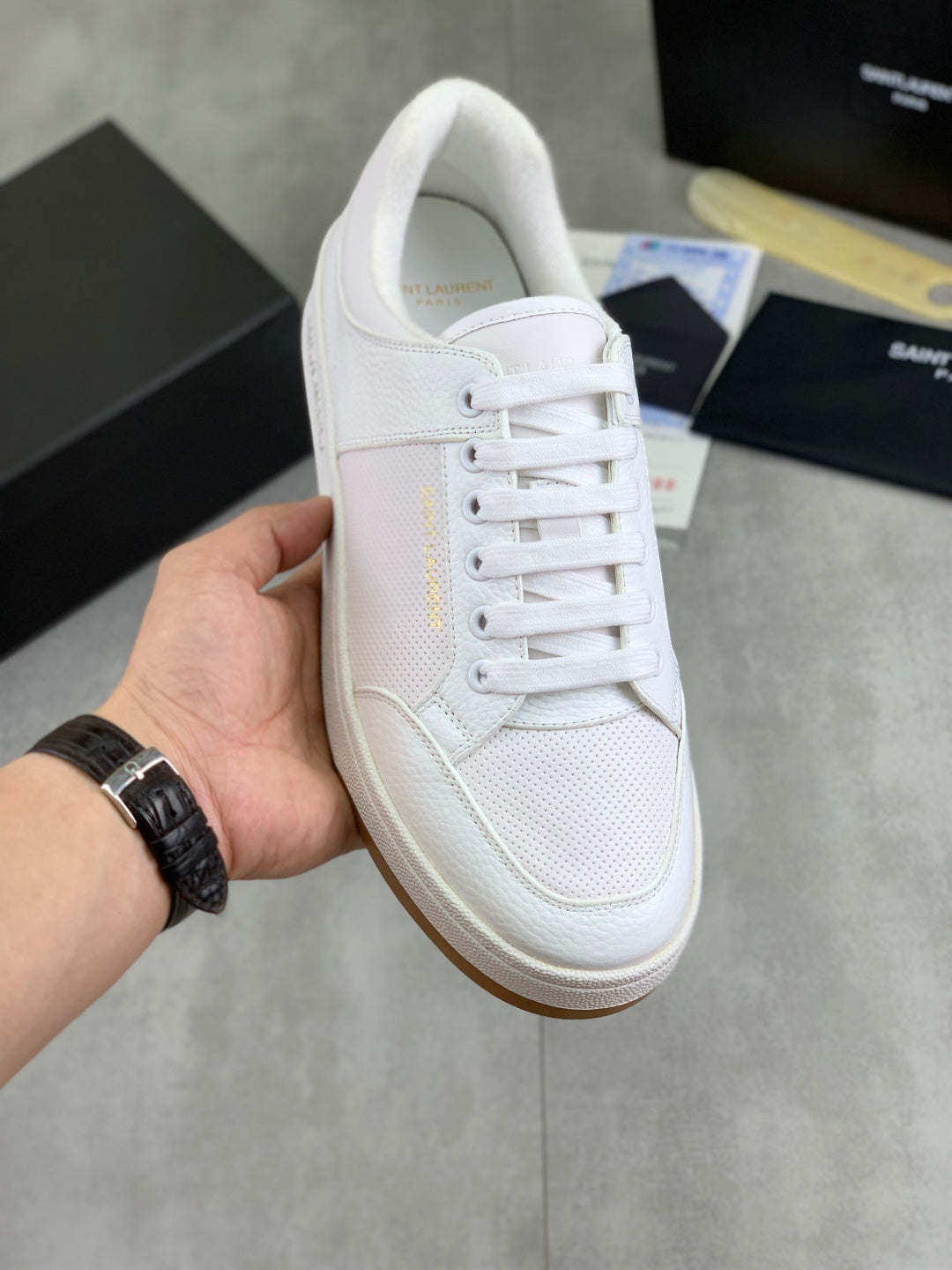 White low-top lace-up sneaker with textured side panel and front eyelets