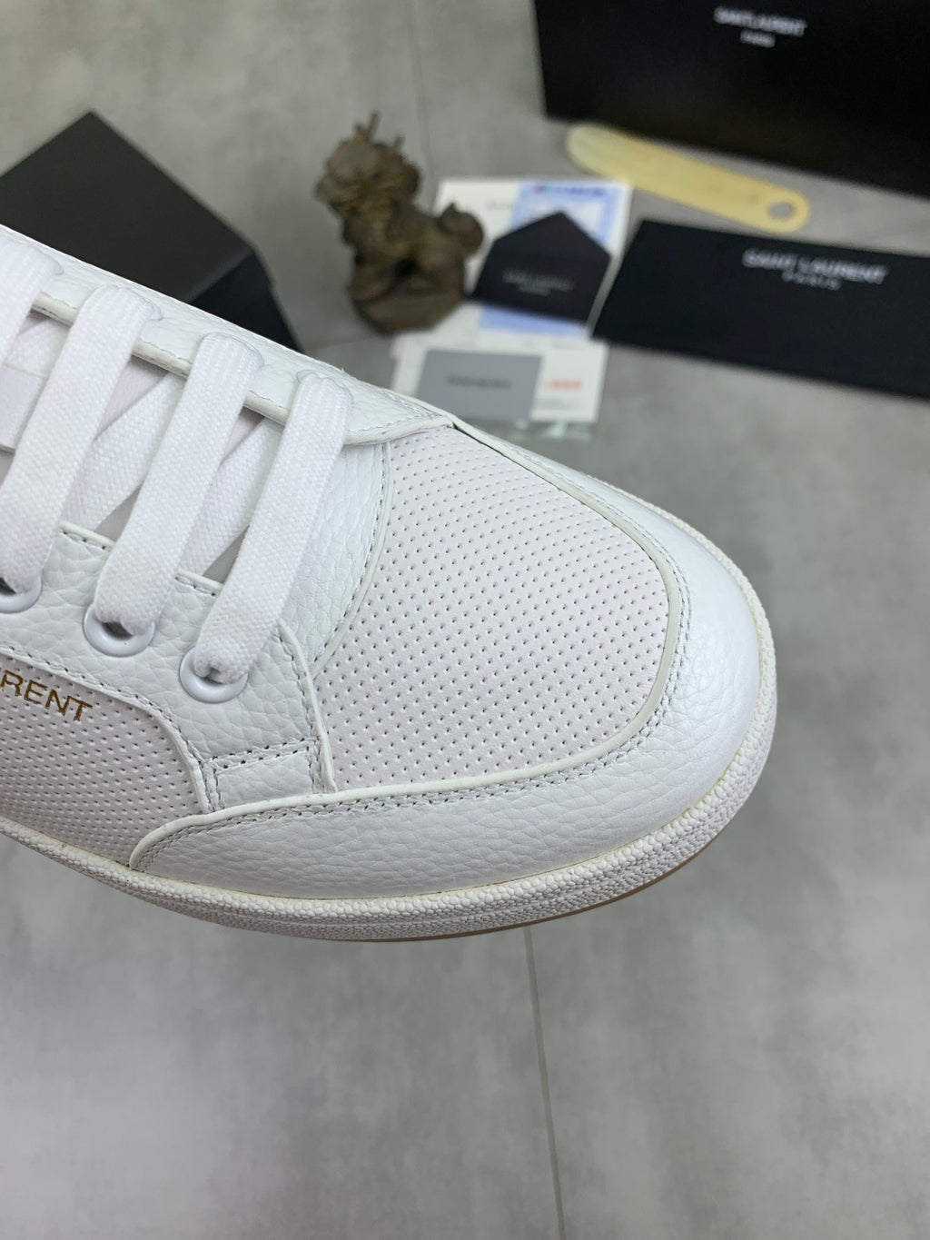 White sneaker toe and lace panel with subtle perforation texture