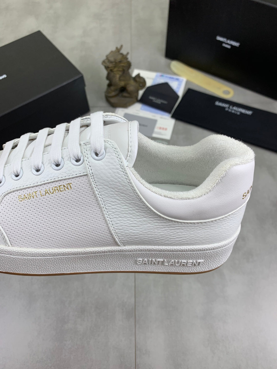 White low-top sneaker with embroidered side logo and cushioned collar