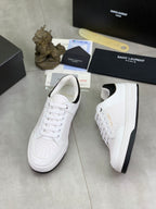 White unisex low-top sneakers with black collar trim and perforated toe