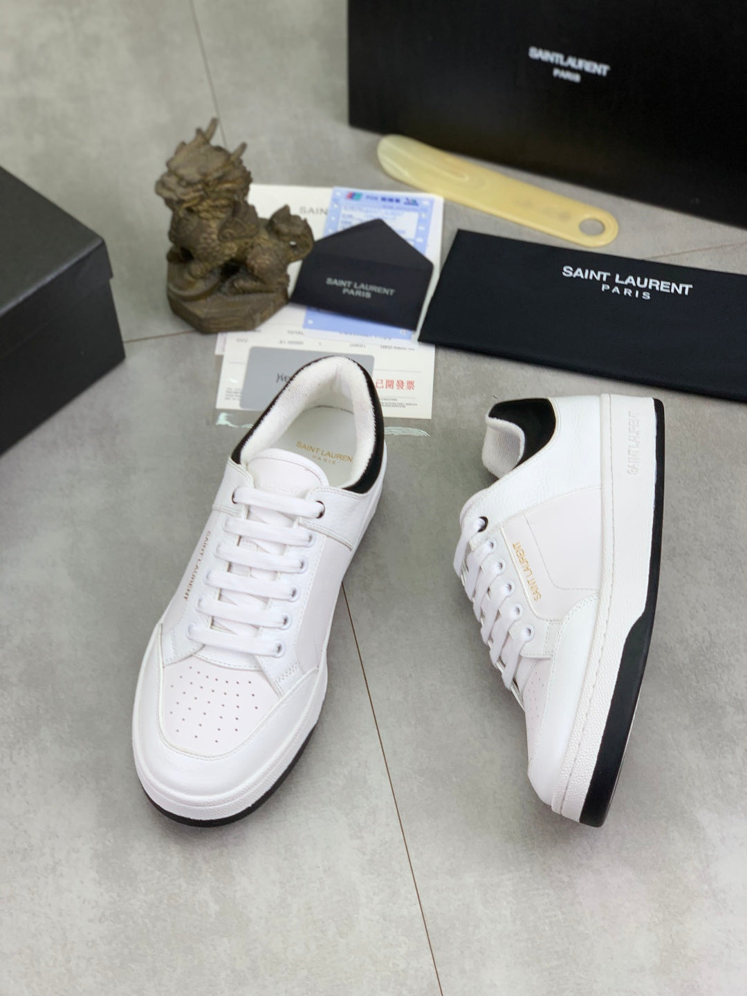 White unisex low-top sneakers with black collar trim and perforated toe