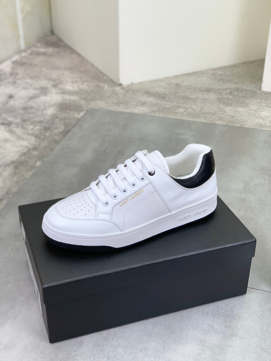 White unisex low-top sneakers with black inner collar and lace-up design