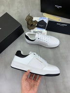 White unisex low-top sneaker with black collar trim and lace-up front