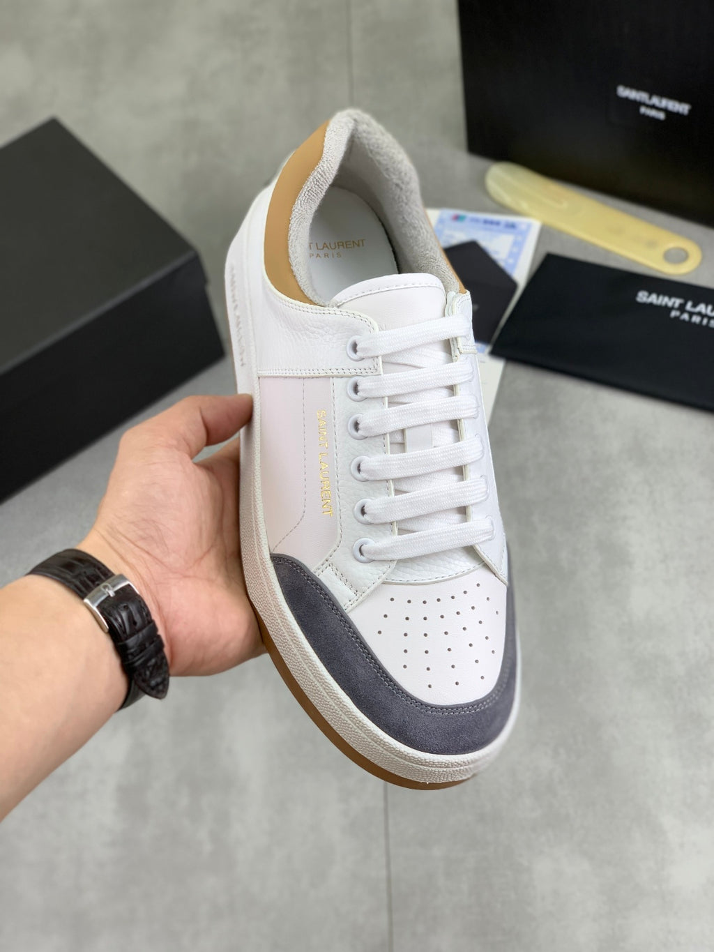 White and navy low-top sneakers, lace-up with perforated toe and gum sole