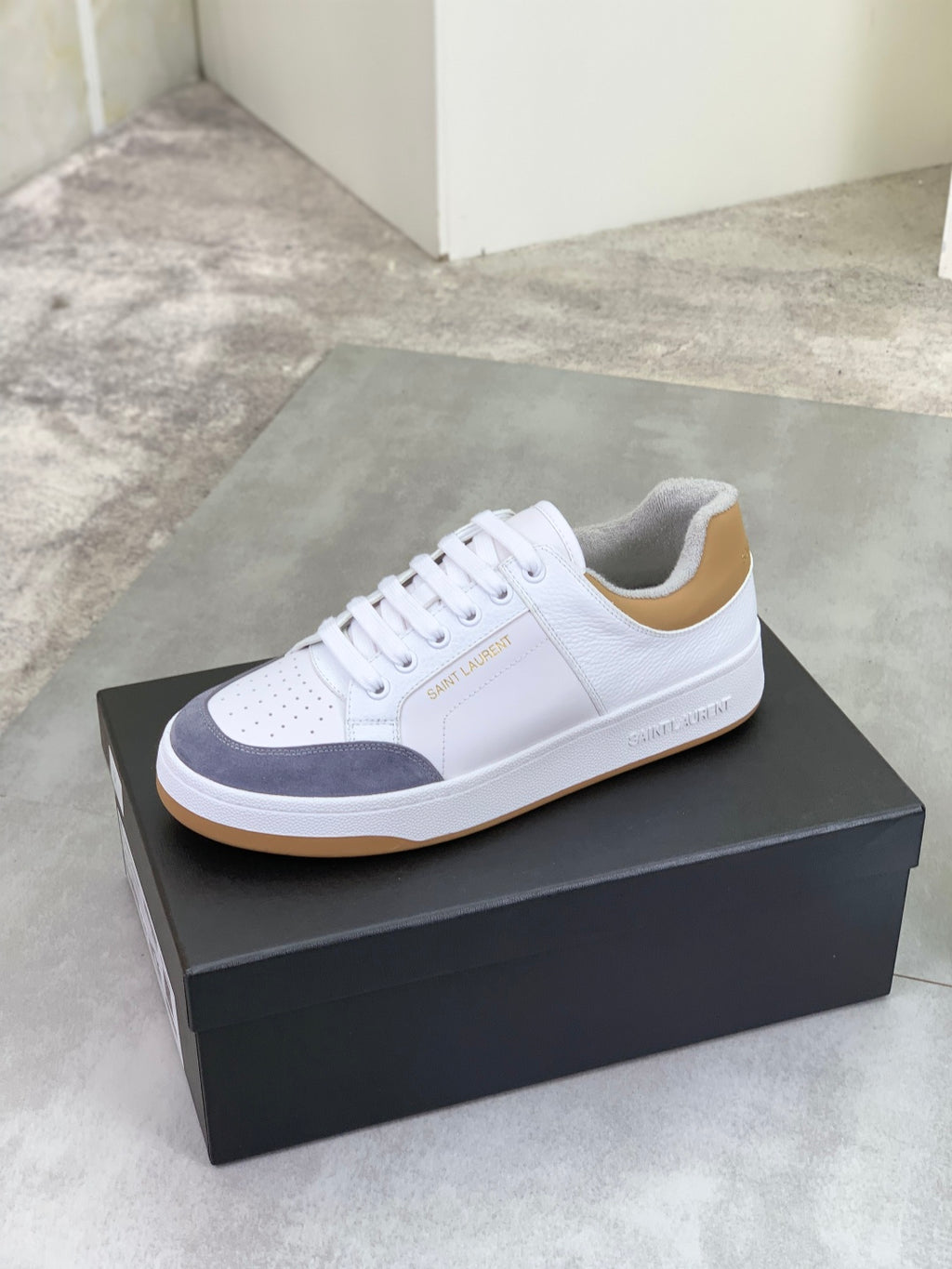 White and navy low-top sneakers with gum sole, lace-up style