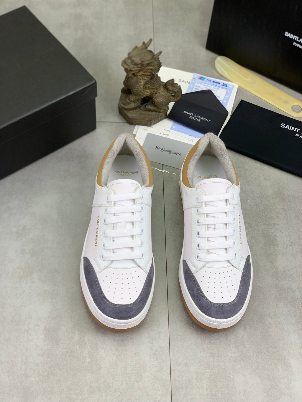 Pair of white low-top sneakers with navy panels, lace-up and gum rubber soles