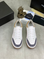Pair of white low-top sneakers with navy panels, lace-up and gum rubber soles