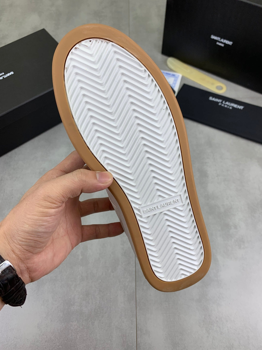 Shoe outsole with white tread pattern and tan rubber edge