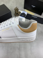 White leather sneakers with gold-toned collar trim and Saint Laurent branding